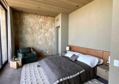 Interior master suite bedroom with wood ceiling, an accent wall, and light beige, elegant hues, designed and painted by CB Paint and Decor in Montecito, Santa Barbara county.